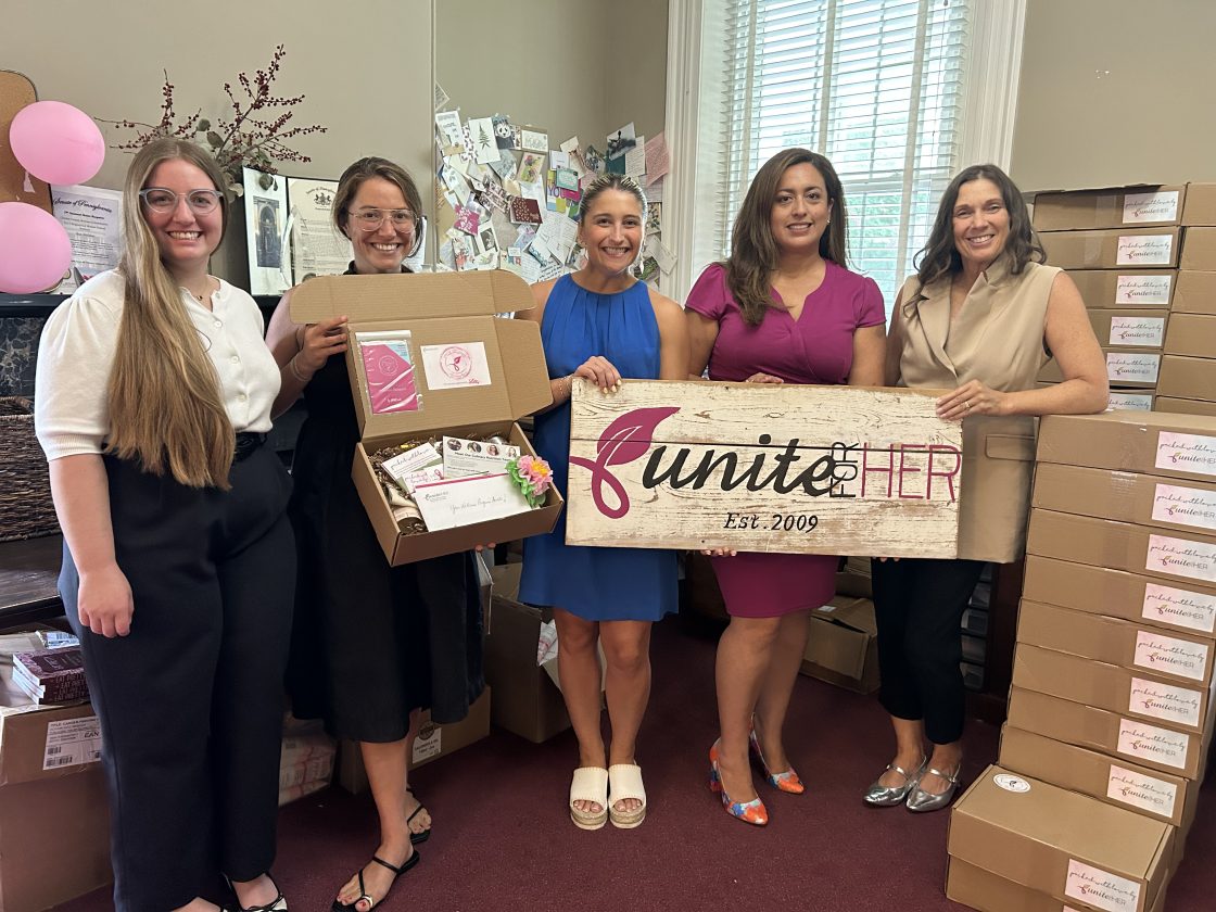 Staff from Unite for HER and the Foxwynd Foundation pose to commemorate the announcement of a new grant to support breast and ovarian cancer patients.