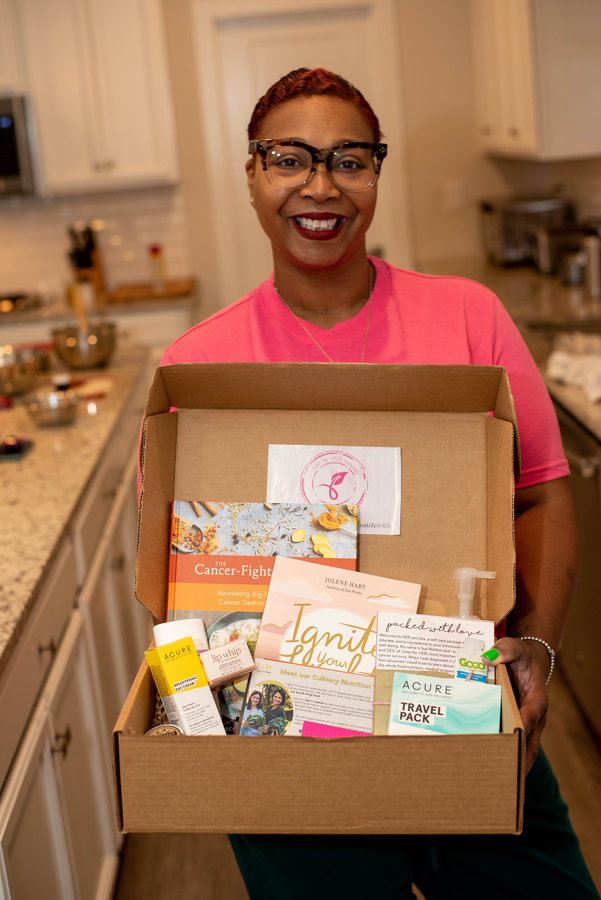 Unite for HER wellness program member holding care box